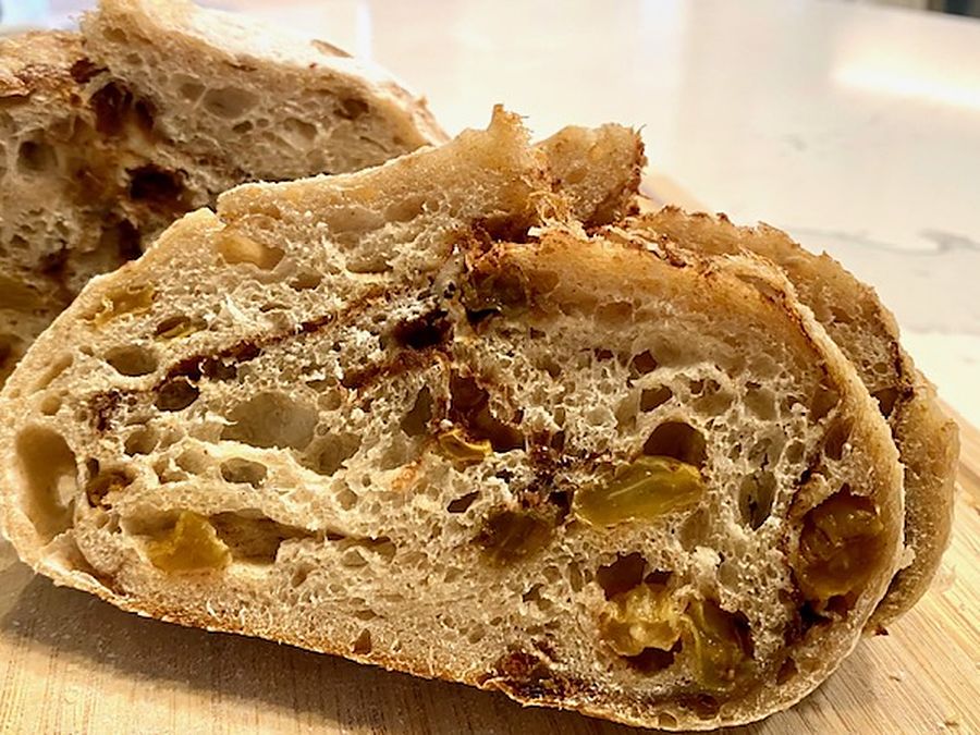 Cinnamon raisin sourdough loaf sliced open showing a cinnamon-marbled crumb packed with golden raisins