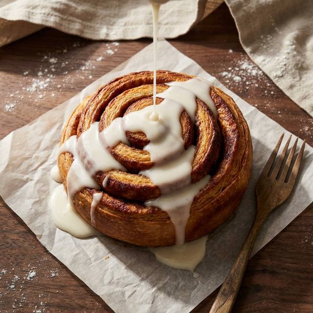 Sourdough cinnamon bun under a thick white vanilla glaze